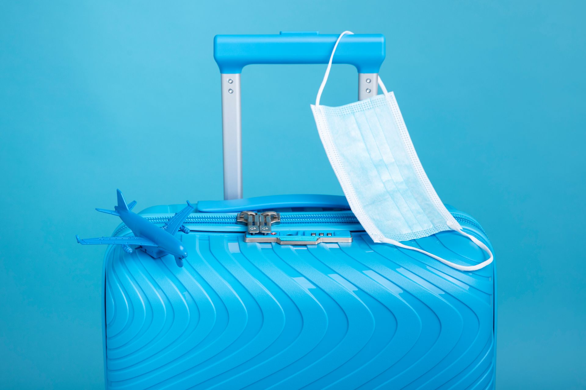 blue-suitcase-travel-with-medical-mask;